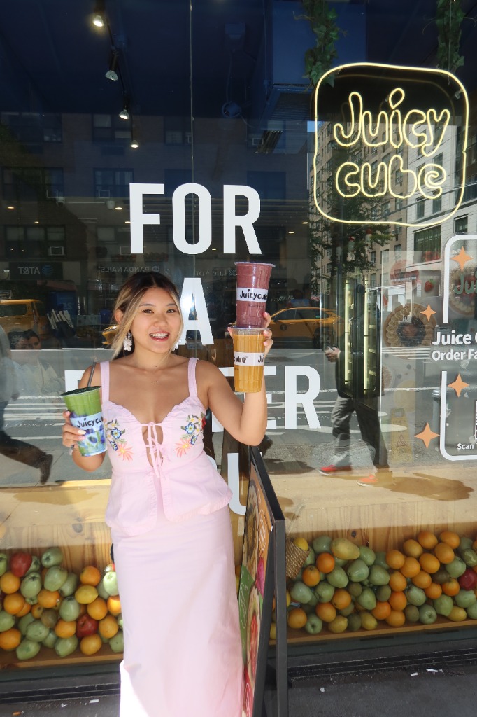 Pinhwa holding smoothies outside Juicy Cube storefront