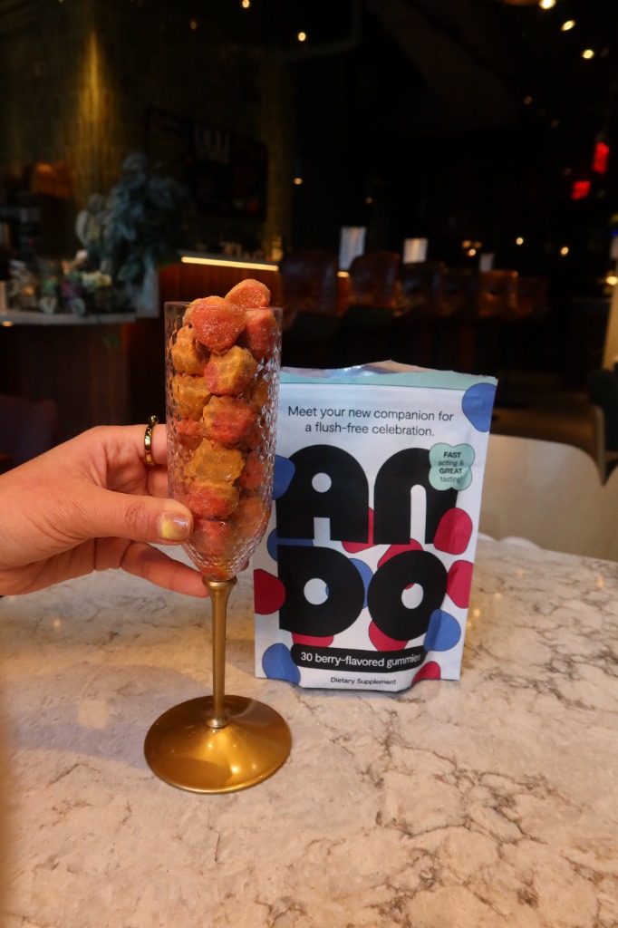 ANDO flush-free gummies and champagne glass product showcase